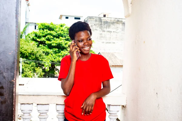 Hermosa Joven Con Camiseta Roja Pie Balcón Casa Mientras Habla — Foto de Stock