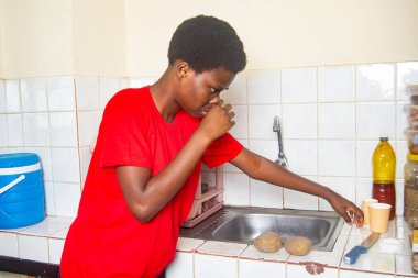 Kırmızı tişörtlü güzel bir kadın mutfakta dikiliyor ve elleriyle burnunu sürterken bıçağı alıyor..