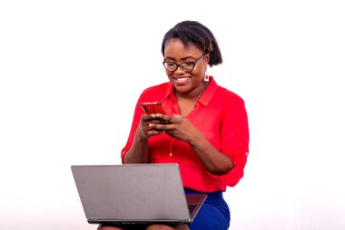 Gülümserken cep telefonu ve dizüstü bilgisayar kullanan güzel bir iş kadınının portresi.