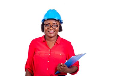 Güzel, yetişkin bir kadın mühendisin portresi mavi güvenlik kaskı takıyor ve gülümserken pano tutuyor..