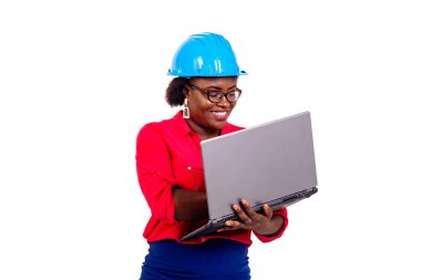 Mavi güvenlik kaskı takan ve gülümserken dizüstü bilgisayarla çalışan güzel bir kadın mühendisin portresi..