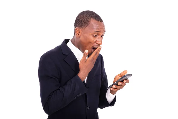Przystojny Biznesmen Kurtce Stojący Białym Tle Patrzący Telefon Komórkowy Dużymi — Zdjęcie stockowe
