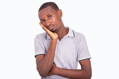 Hayal kırıklığına uğramış ve mutsuz genç bir adam. Şaşırmış bir yüz ifadesi var. Elleri ve yanakları çaprazlanmış..