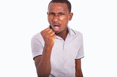 Öfkeli yetişkin bir adam beyaz arka planda yumruğunu kaldırıyor..