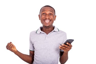 Yakışıklı genç adam içeride duruyor, elinde cep telefonu var ve kazanıyor..