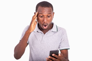 Genç, ağzı açık, cep telefonuna bakan, şaşırmış bir adam..