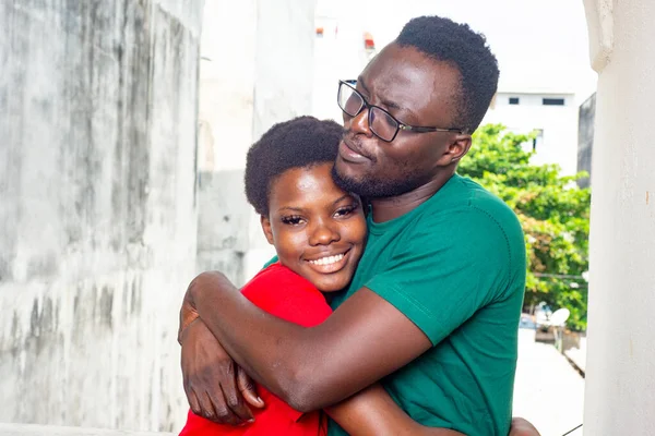 Νεαρός Άνδρας Αγκαλιάζει Την Κοπέλα Του Στο Σπίτι Χαμογελώντας — Φωτογραφία Αρχείου