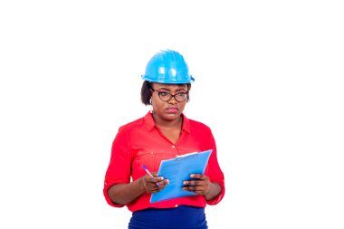 Güzel bayan mühendis mavi güvenlik kaskı takıyor, düşünüyor ve pano tutuyor..