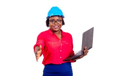 Mavi kasketli güzel bir kadın mühendisin portresi dizüstü bilgisayar tutuyor ve gülümserken el sıkışıyor..