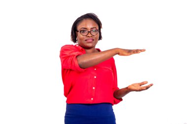 Optik gözlük takan genç bir iş kadınının portresi ve gülümseyerek iki eliyle büyük boy jest yapıyor..