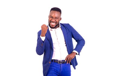 Yakışıklı, mutlu, genç bir iş adamının portresi. Zarif bir takım elbise giymiş ve kolunu kaldırarak zafer jesti yapıyor..