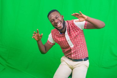 Gülümserken iki eliyle komik suratlar yapan yakışıklı bir gencin portresi..