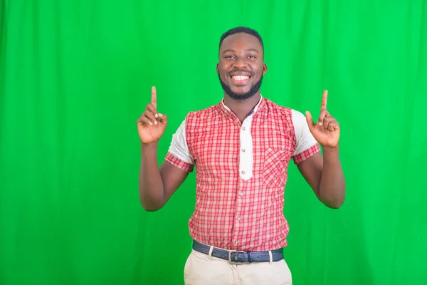 Portrait Happy Handsome Young Man Standing Green Background Pointing Index — Stock Photo, Image