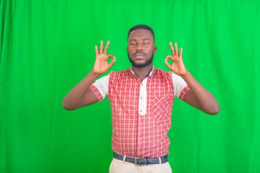 Gözleri kapalı genç bir adamın portresi parmaklarıyla doğru jestler yapıyor..