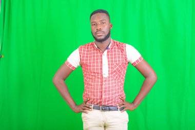 Kameraya bakarken iki elini de kalçanda tutan yakışıklı bir gencin portresi..