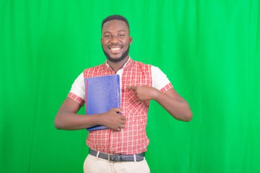 Yakışıklı bir iş adamının portresi gülümserken bir defteri işaret ediyor..