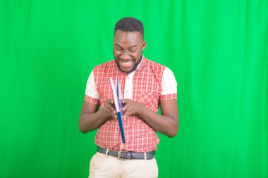 Yakışıklı bir iş adamının portresi gülümserken bir not defteri açıyor..