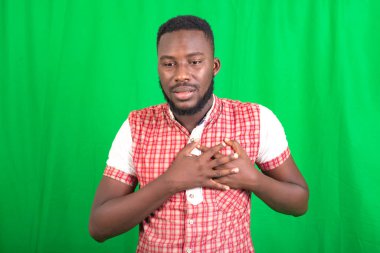 Arka planda duran sakallı yakışıklı bir adam göğsüne dokunurken kalbinde acı hissediyor..