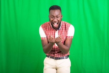 Kızgın ve kızgın giyinmiş genç yakışıklı bir adam öfkeyle bağırırken kızgın ve öfkeli yumruklar sallıyor. öfke ve agresif konsept.