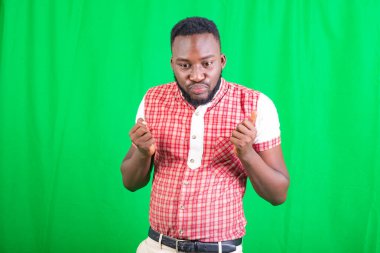 Yakışıklı bir gencin portresi. Bir eliyle yumruğunu sıkıyor, diğer eliyle başparmağını kaldırıyor..