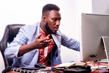 Yakışıklı genç iş adamı, ofisteki dizüstü bilgisayarda kötü haberleri görünce şaşırdı ve el kaldırdı..