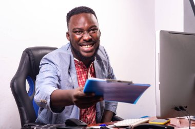 Genç mutlu iş adamı sırasına oturmuş gülümserken pano veriyor..