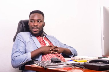 Ceketli bir işadamı masasında oturmuş biriyle konuşuyor..