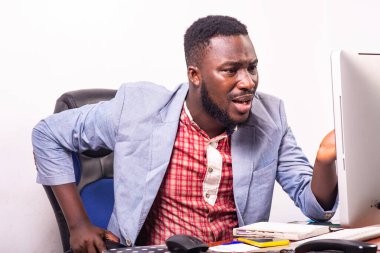 Şaşırmış iş adamı ofisteki laptop ekranına bakıyor..