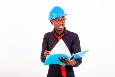 Başlık takan genç bir mühendisin portresi belgeleri okuyor ve kontrol ediyor..