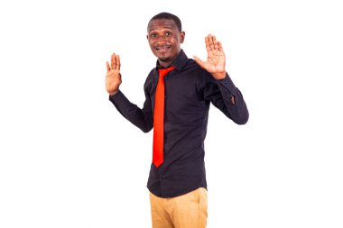 Beyaz arka planda duran ve gülümseyen iki elini kaldıran genç bir iş adamının portresi..