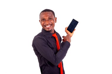 Gülümserken bir cep telefonunu işaret eden mutlu bir gencin portresi.