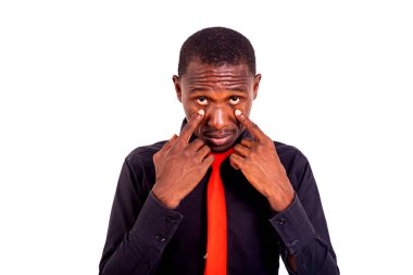 Ayakta duran ve parmaklarını gözlerine yaklaştıran yakışıklı bir gencin portresi..