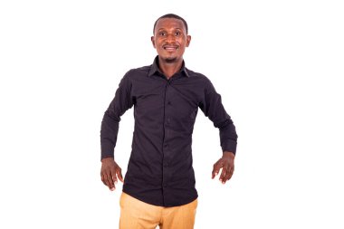 Beyaz arka planda duran yakışıklı bir işadamı kameraya bakıp gülümsüyor..