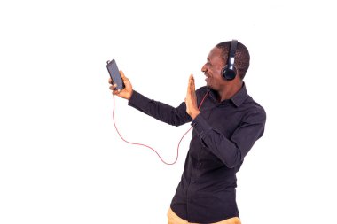 Beyaz bir arkaplanda dikilip gülümseyen bir video konuşması yapan bir öğrenci..