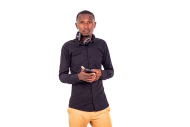 Boynunda kulaklıkla beyaz arka planda duran tişörtlü bir öğrenci..