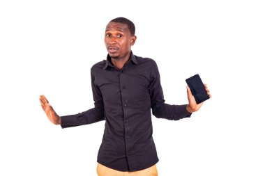 Beyaz arka planda oturan, cep telefonuyla konuşan omuz silken tişörtlü bir öğrenci..