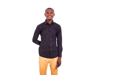 Beyaz arka planda duran tişörtlü bir öğrenci kameraya bakıp gülümsüyor..