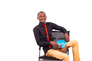 Bir sandalyede oturan yakışıklı genç bir işadamının portresi ve bir cep telefonu ve bir klasör ile gülümserken..