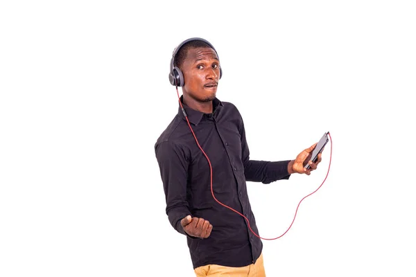 穿着衬衫站在白色背景上 用耳机和手机听音乐的学生 — 图库照片