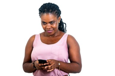 Güzel bir genç kadının portresi beyaz bir arkaplanda cep telefonu kullanarak duruyor..