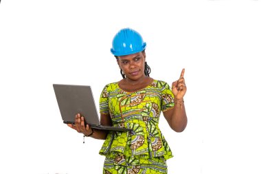 Güzel genç bayan mühendis, elinde dizüstü bilgisayarla işaret parmağını kaldırıyor..