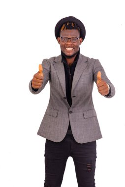 Yakışıklı, iyi giyimli genç bir iş adamının portresi. Kameraya gülümserken başparmağını kaldırıyor..