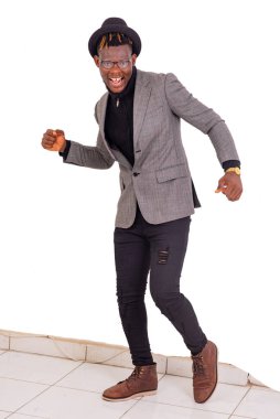 Yakışıklı genç bir iş adamının portresi zarif bir takım elbise ve siyah bir şapka giyerken gülümsüyor..