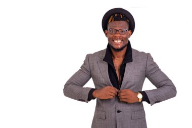 Yakışıklı bir iş adamının gülümseyerek ceketinin düğmelerini ilikleyen portresi..