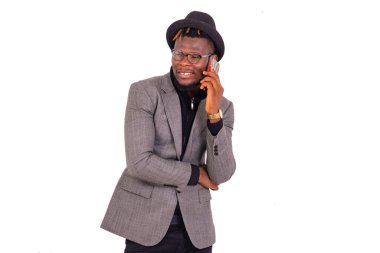 Zarif takım elbiseli yakışıklı bir iş adamı cep telefonuyla konuşurken gülümsüyor..