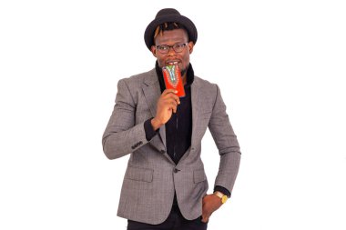 Zarif takım elbiseli ve elinde cep telefonu olan yakışıklı bir iş adamı..