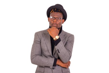 Yakışıklı genç bir iş adamının portresi şık bir takım elbise giyiyor ve kollarını kavuşturup çenesini kaldırarak düşünüyor..