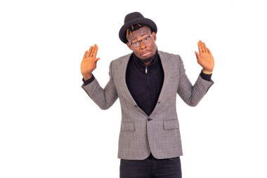 Zarif bir takım giyen, omuzlarını silkeleyen ve ellerini kaldıran yakışıklı, belirsiz bir iş adamının portresi..