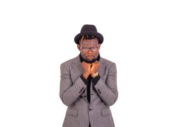 Yakışıklı, üzgün, genç bir iş adamının portresi zarif bir takım elbise giymiş ve parmaklarını çenesinin altında çapraz yapıyor..