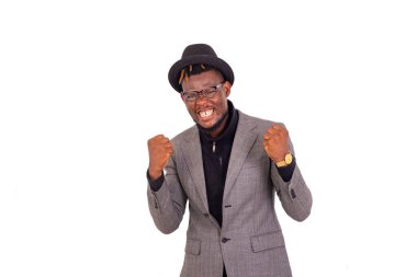 Yakışıklı genç bir işadamının portresi şık bir takım elbise giyiyor ve kollarını kaldırıp gülümsüyor..